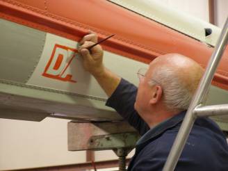 Stuart paints DANGER stencil on the tail boom.